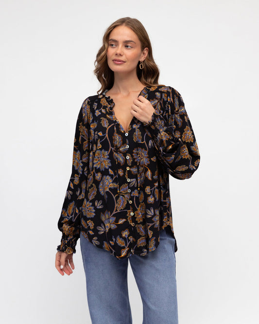 Woman wearing a floral blouse with a plain background